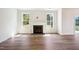 Bright living room with hardwood floors, fireplace, and natural light from two large windows at 73 Artic Cir, Garner, NC 27529