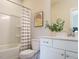 Well-lit bathroom featuring a shower-tub combo, modern vanity, and a decorative mirror at 1156 Cottonsprings Dr, Wendell, NC 27591