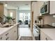 Modern kitchen featuring white cabinets, stainless steel appliances, and a view of the living area at 1156 Cottonsprings Dr, Wendell, NC 27591