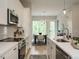 Modern kitchen with white cabinets, stainless steel appliances, and an open view of the dining area at 1156 Cottonsprings Dr, Wendell, NC 27591