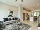 Open-concept living room showcasing an art piece, modern coffee table, and seamless transition to a well-equipped kitchen at 1156 Cottonsprings Dr, Wendell, NC 27591