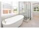 Bright bathroom with a standalone soaking tub, and a glass-enclosed shower at 3402 St Barts Pl, Mebane, NC 27302