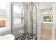 Modern bathroom with glass-enclosed shower, soaking tub, and stylish gray tiling at 3402 St Barts Pl, Mebane, NC 27302