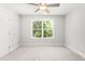 This is a carpeted bedroom with a ceiling fan and a view of nature at 3402 St Barts Pl, Mebane, NC 27302