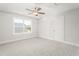 Bright, carpeted bedroom with a large window and modern ceiling fan at 3402 St Barts Pl, Mebane, NC 27302