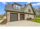 Spacious three-car garage with modern doors and ample driveway space, attached to the house at 3402 St Barts Pl, Mebane, NC 27302