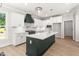 Bright modern kitchen with island, white cabinets, and sleek stainless steel appliances at 3402 St Barts Pl, Mebane, NC 27302