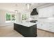 Bright kitchen featuring a large island, white cabinets, and modern light fixtures at 3402 St Barts Pl, Mebane, NC 27302