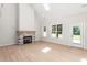 Open-concept living room featuring large windows, fireplace, and wood flooring at 3402 St Barts Pl, Mebane, NC 27302
