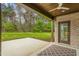 A covered brick patio with a ceiling fan, looking out onto a grassy backyard at 3402 St Barts Pl, Mebane, NC 27302
