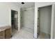 Bathroom featuring a tiled shower, vanity, and doorways to storage spaces at 316 Firefly Overlook, Pittsboro, NC 27312
