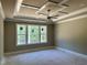 Spacious bedroom boasts large windows offering serene views and tray ceiling with fan at 316 Firefly Overlook, Pittsboro, NC 27312