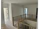 Hallway with natural wood railings and black metal balusters overlooking the staircase below at 316 Firefly Overlook, Pittsboro, NC 27312