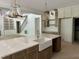 The kitchen island with a white farmhouse sink is complemented by brass fixtures and stylish pendant lights at 316 Firefly Overlook, Pittsboro, NC 27312