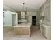 Spacious kitchen features a central island, custom cabinetry, and modern pendant lighting at 316 Firefly Overlook, Pittsboro, NC 27312