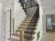 Stylish staircase featuring light wood treads, white risers, and black metal balusters at 316 Firefly Overlook, Pittsboro, NC 27312