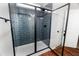 Elegant glass-enclosed shower with blue tile and sleek black fixtures in a modern bathroom at 4466 Debnam Rd, Zebulon, NC 27597
