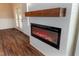 Modern fireplace with sleek design, wooden mantel, and elegant wall paneling at 4466 Debnam Rd, Zebulon, NC 27597