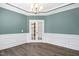 Elegant dining room features hardwood floors, wainscoting, and a stunning chandelier at 21 Walnut Hall Ct, Selma, NC 27576