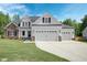 Two-story house with stone and white siding, three-car garage, and manicured lawn at 21 Walnut Hall Ct, Selma, NC 27576