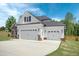 Three-car garage with white doors and stone accents at 21 Walnut Hall Ct, Selma, NC 27576