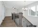 Upstairs hallway with wood railing, chandelier, and carpet flooring at 21 Walnut Hall Ct, Selma, NC 27576