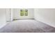 Bright and airy bedroom with soft carpet and a large window showing a lush green view at 83 Artic Circle, Garner, NC 27529