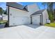 Spacious driveway and multi-car garage with carriage doors enhance this charming, modern home at 83 Artic Circle, Garner, NC 27529