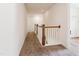 Upstairs hallway with carpet and wooden railing at 83 Artic Circle, Garner, NC 27529