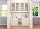 Stylish bar area with custom cabinetry, a wine fridge, and elegant glass display cabinets in an entertaining space at 154 Colonial Trail Ct, Pittsboro, NC 27312