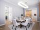 Elegant dining area featuring modern lighting and a view into the kitchen at 154 Colonial Trail Ct, Pittsboro, NC 27312