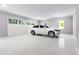 Clean, spacious garage with a white car parked inside with natural light from windows and garage doors at 154 Colonial Trail Ct, Pittsboro, NC 27312