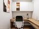 Functional home office featuring built-in desk, overhead cabinets, and a comfortable chair for a productive workspace at 154 Colonial Trail Ct, Pittsboro, NC 27312