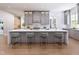 Kitchen featuring gray cabinets, a large white island with seating, and hardwood floors throughout the space at 154 Colonial Trail Ct, Pittsboro, NC 27312