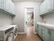 Well-organized laundry room with modern appliances, ample cabinet space, and a view into a walk-in closet at 154 Colonial Trail Ct, Pittsboro, NC 27312