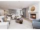 Bright living room showcasing a fireplace, living room and a glimpse into the modern kitchen with gray cabinets at 154 Colonial Trail Ct, Pittsboro, NC 27312