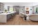 Open-concept living space showcasing a modern kitchen, fireplace, and comfortable seating area with wood flooring at 154 Colonial Trail Ct, Pittsboro, NC 27312
