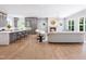 Bright and airy living room featuring a fireplace, hardwood floors, and stylish gray kitchen in an open layout at 154 Colonial Trail Ct, Pittsboro, NC 27312