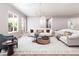 Spacious living room featuring white sofas, a chandelier, and a gray-blue sitting chair and hardwood floors at 154 Colonial Trail Ct, Pittsboro, NC 27312
