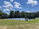 Well-maintained community tennis court surrounded by lush trees and blue skies at 154 Colonial Trail Ct, Pittsboro, NC 27312