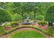 Outdoor water fountain surrounded by lush landscaping and mature trees in a park-like setting at 8305 Society Pl, Raleigh, NC 27615