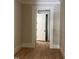 Bright hallway with white trim, light hardwood floors and an open doorway leading to another room at 8305 Society Pl, Raleigh, NC 27615