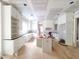 Spacious kitchen featuring white cabinetry, a central island, and hardwood flooring at 8305 Society Pl, Raleigh, NC 27615