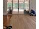 Freshly varnished light hardwood floors span the sunlit living room with double doors to the porch at 8305 Society Pl, Raleigh, NC 27615