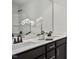 Elegant bathroom featuring double sinks, vanity with dark cabinets, and white flowers at 176 Van Winkle St, Lillington, NC 27546