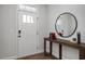Clean foyer with light walls and a modern accent table and round mirror at 176 Van Winkle St, Lillington, NC 27546