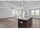 Open concept kitchen with large island, hardwood floors and views into living area at 176 Van Winkle St, Lillington, NC 27546