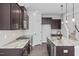 Modern kitchen with dark cabinets, granite countertops, and stainless steel appliances at 176 Van Winkle St, Lillington, NC 27546