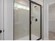 Sleek walk-in shower with a tiled enclosure, black fixtures, and a glass door at 176 Van Winkle St, Lillington, NC 27546