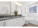 Elegant bathroom featuring double sinks, framed mirrors, and a soaking tub with marble accents, creating a spa-like retreat at 4015 Elk Creek Ln, Raleigh, NC 27612